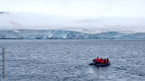 Zodiac inflatable boat navigating in front of a glacier at Kinnes Cove, Joinville Island, Antarctica