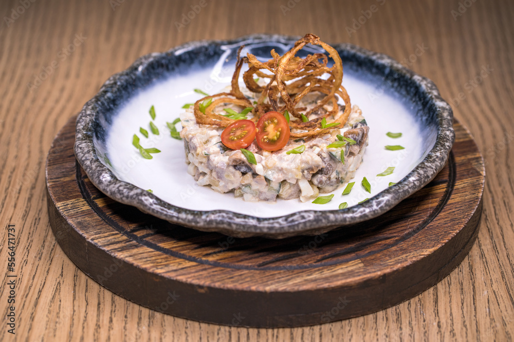 Restaurant dish meat salad on a blue plate Restaurant dish meat salad on a blue plate
