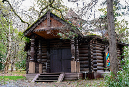 Wooden house with carved columns and platbands in the forest