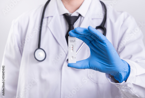 A doctor holds a self-test kit that is positive for COVID-19 antigen