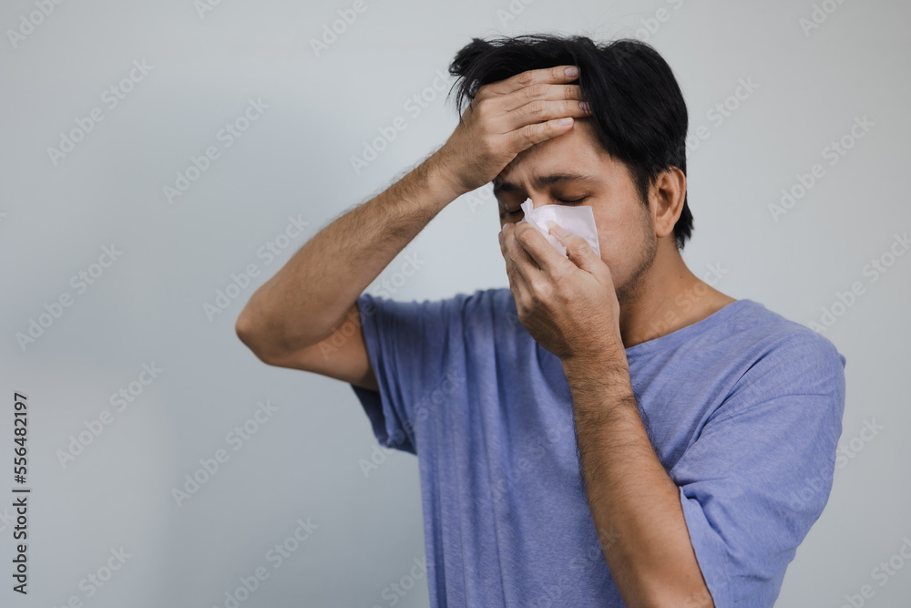 Portrait Of Sick Asian man covering his mouth and nose with a tissue Portrait Of Sick Asian man covering his mouth and nose with a tissue