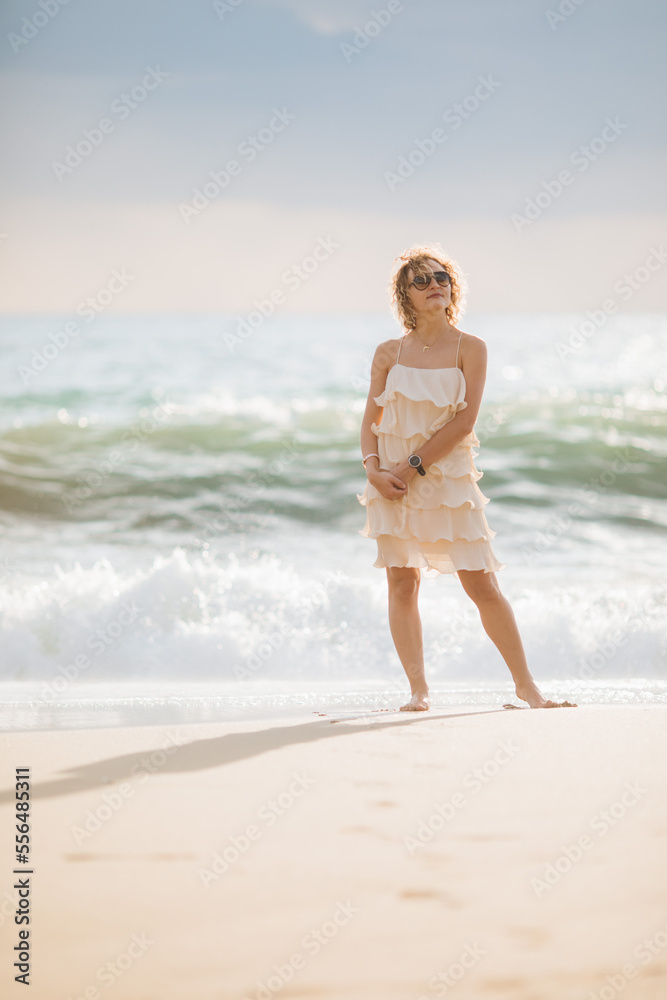 The girl walks along the shore along the sea at sunset. The girl walks along the shore along the sea at sunset.
