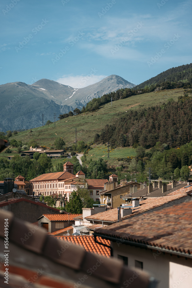 Orange roofs of modern houses in small village of Ribes de Freser at foot of Pyrenees in Spain. Sunlight illuminates beautiful village with picturesque mountain nature and beautiful architecture. Orange roofs of modern houses in small village of Ribes de Freser at foot of Pyrenees in Spain. Sunlight illuminates beautiful village with picturesque mountain nature and beautiful architecture.