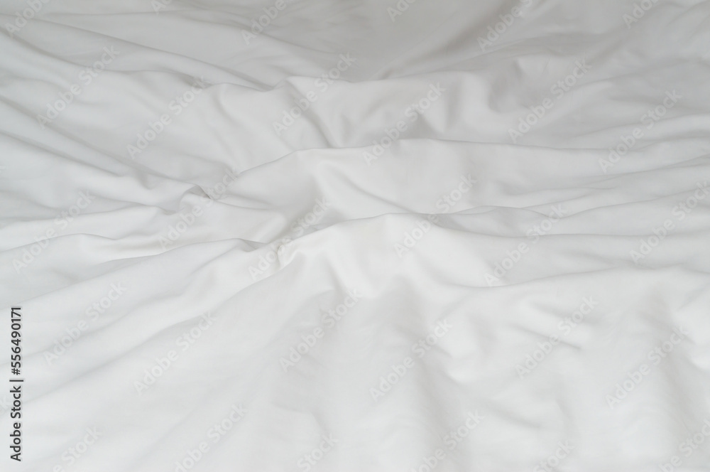 White crumpled or wrinkled bedding sheet or blanket with pattern after guest's use taken in hotel, resort room with copy space, Untidy blanket background texture
