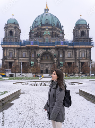 Photography Young female tourist walking in the park in front of the Berlin Cathedral with snow all over the ground