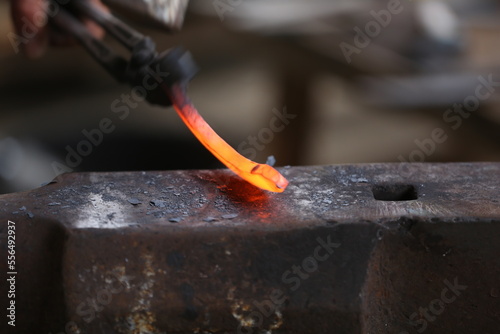 Blacksmith working at smithy workshop