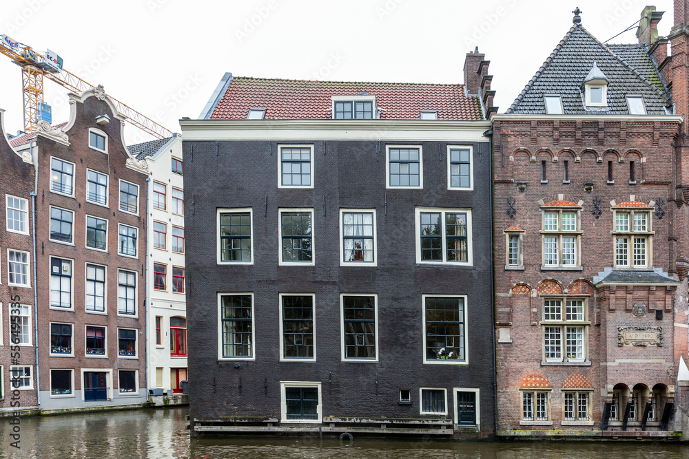Traditional brick houses on canal street in Amsterdam. Front view.