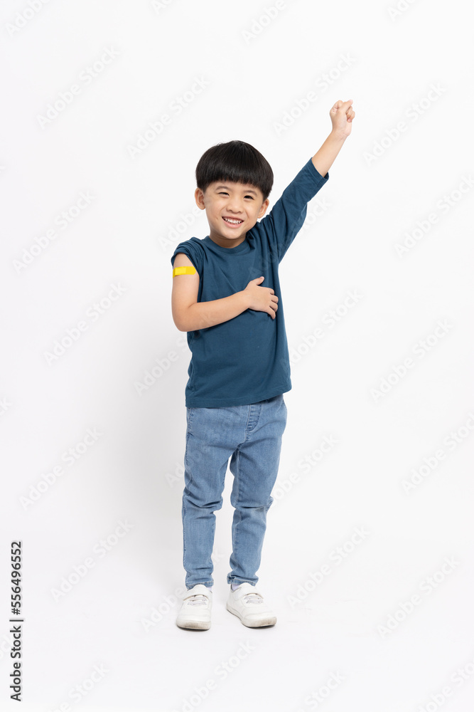 Happy Asian little boy showing arm with plaster of Hand-foot-mouth disease vaccine isolated on white background, Adhesive bandage on arm after injection of vaccine concept, Five years old Happy Asian little boy showing arm with plaster of Hand-foot-mouth disease vaccine isolated on white background, Adhesive bandage on arm after injection of vaccine concept, Five years old
