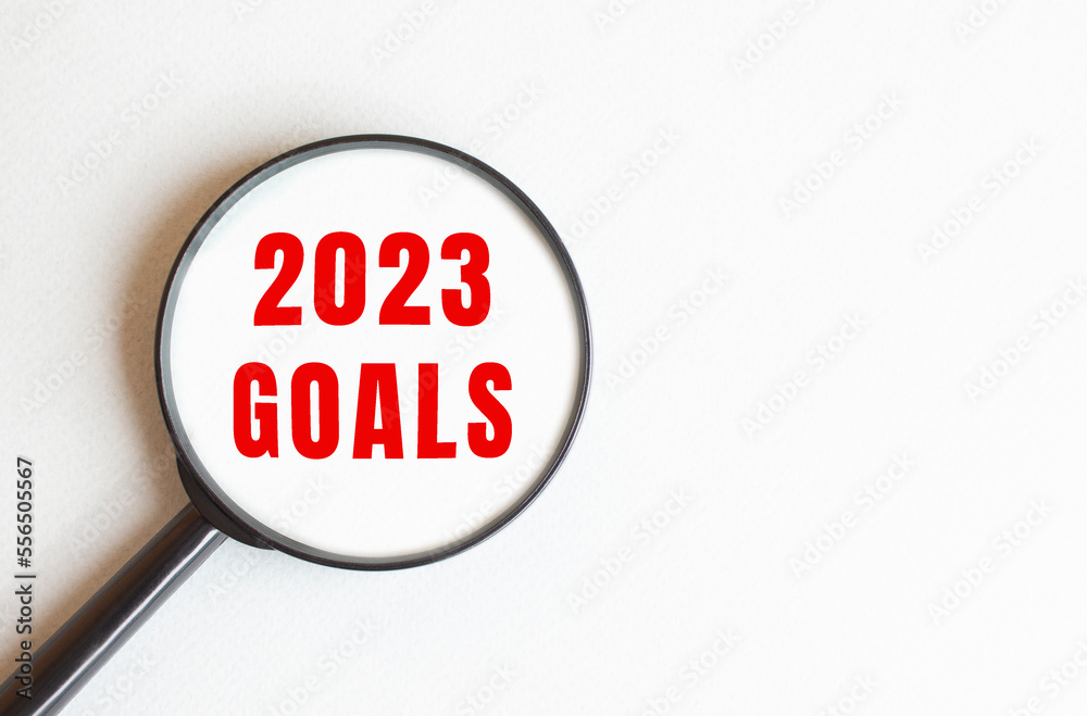 The text 2023 GOALS is written on a gray background. We read through a magnifying glass. The text 2023 GOALS is written on a gray background. We read through a magnifying glass.