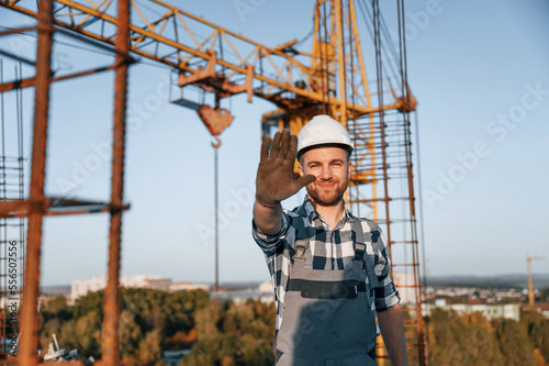 Stop gesture by the hand. Man is working on the construction site at daytime © standret
