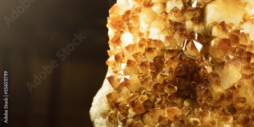 Citrine stone macro crystalls with small depth of field. Yellow quartz on dark background,banner photo