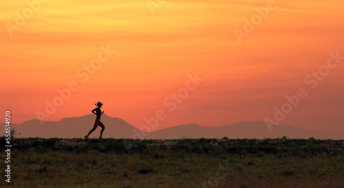 Solitary jogger silhouetted against a dawn sky