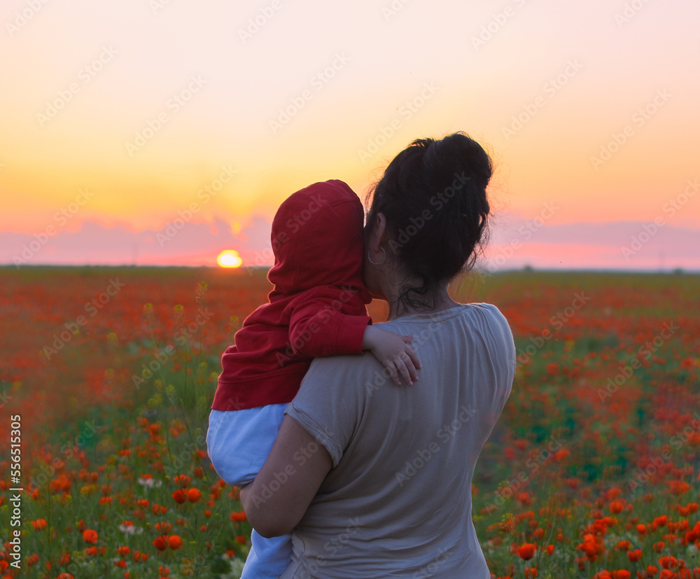 mom and son on the poppy field look at the beautiful sunset mom and son on the poppy field look at the beautiful sunset
