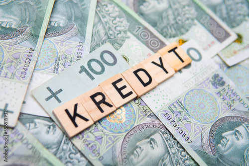 Inscription Kredyt which means debt in polish, next to money. Concept showing rising interest rates in Poland and high debt costs in Poland