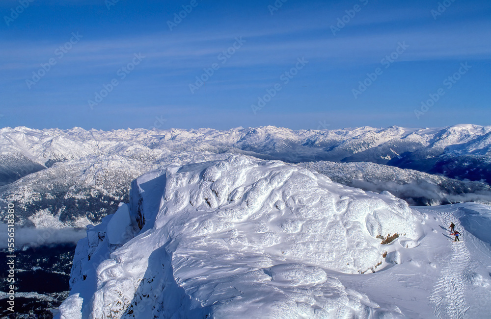 Skiers climbing Whistler mountain