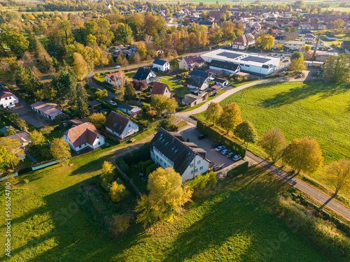 Aerial view of houses in the countryside in Kremmen, Brandenburg with fields and forest surrounding in Autumn, Germany