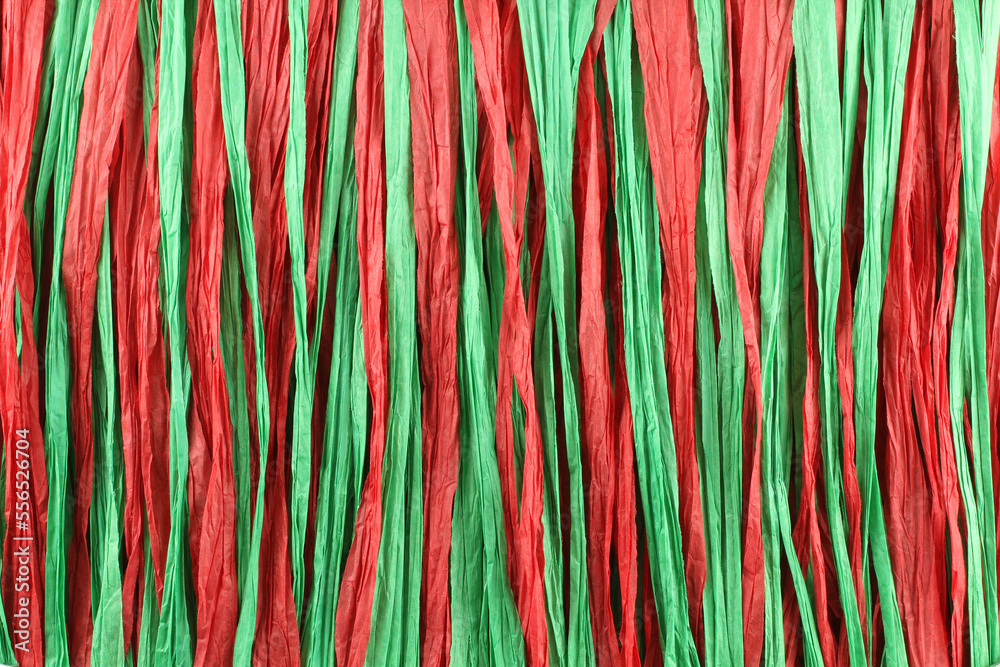 Background - red and green paper raffia strips situated in parallel lines