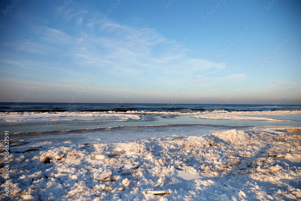 Winter view on the icy sea coast and beautiful calm sky, selective focus