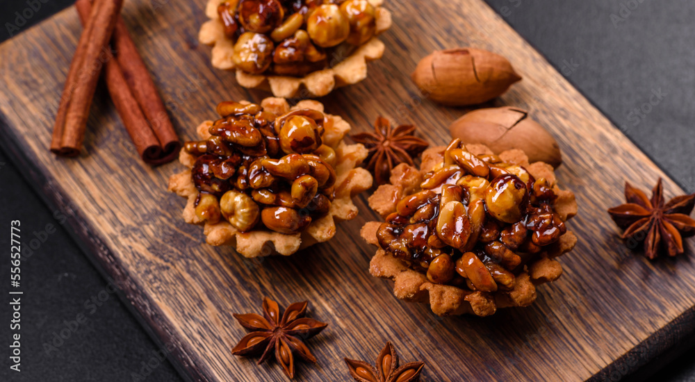 Sweet tasty tart with nuts and honey on a dark concrete background