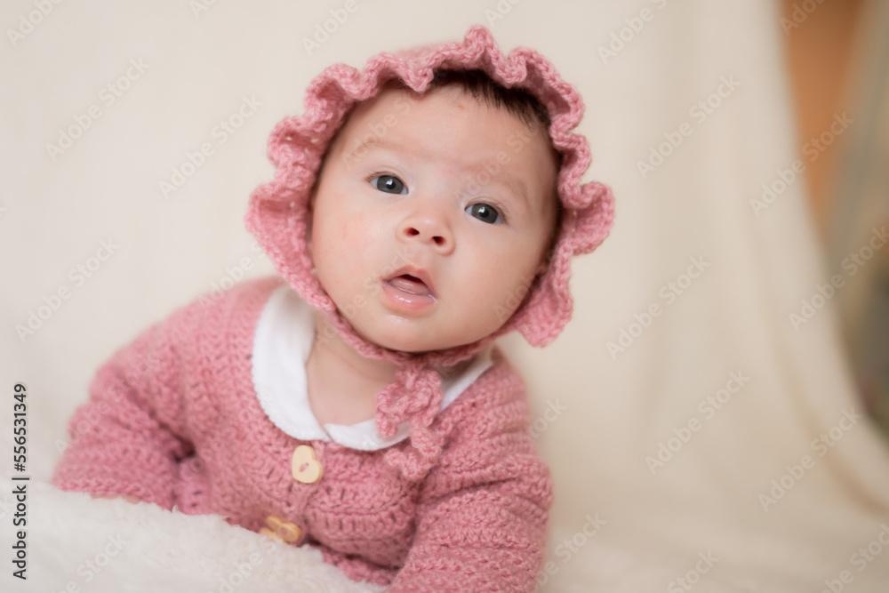 beautiful portrait of adorable mixed ethnicity Asian Caucasian baby girl a few weeks old lying on white blanket wearing a sweet pink hat in new life and newborn concept beautiful portrait of adorable mixed ethnicity Asian Caucasian baby girl a few weeks old lying on white blanket wearing a sweet pink hat in new life and newborn concept