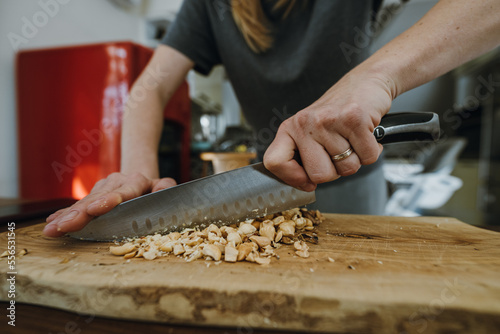 Female hands chopping hazelnuts for cooking pastry.