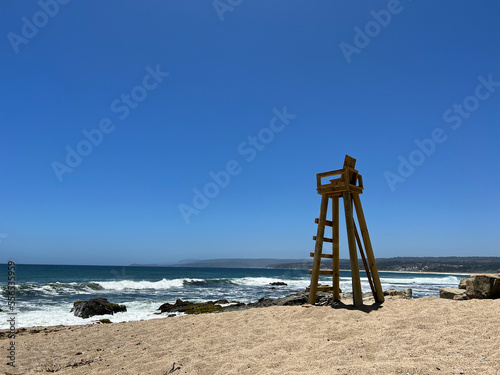 wooden lifeguard chair in a solitary beach sea sand