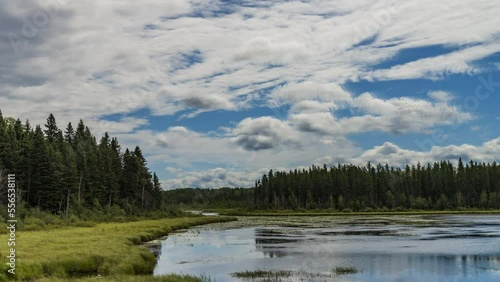Forest pond with timelapsed clouds in Prince Albert National Park photo