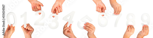 Children's hands hold numbers. A set of white numbers in hands on a black isolated background. Zero, one, two, three, four, five, six, seven, eight, nine