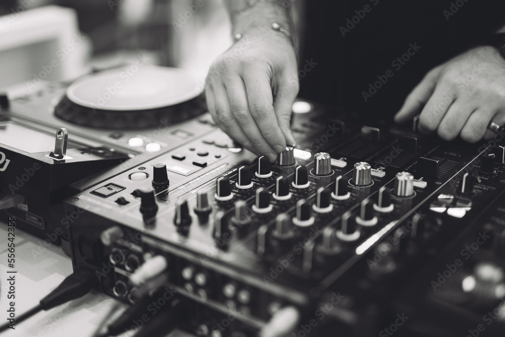 Fototapeta premium a DJ plays music on a controller at a party.