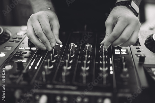 a DJ plays music on a controller at a party.