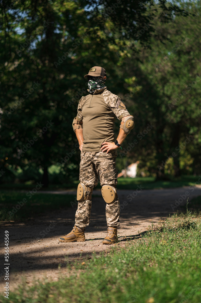 Soldier in protective uniform. Protective camouflage uniform. Elbow pads and knee pads for soldiers