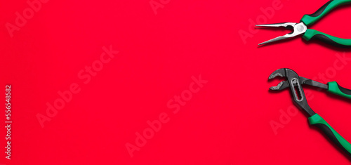 A set of quality green building tools to repair a car or a house on a red background. Do it yourself instruments. Banner for advertising construction shop with copy space. Business card