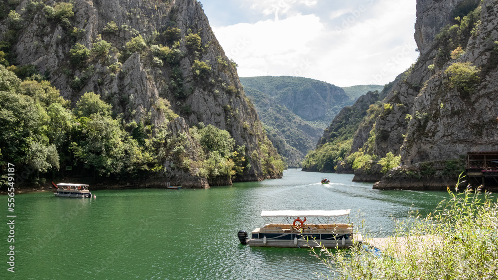 Matka canyon in North Macedonia near Skopje, boat on the lake, boat trip, Matka lake and mountain view with sky, colorful boat for tourists - obrazy, fototapety, plakaty 