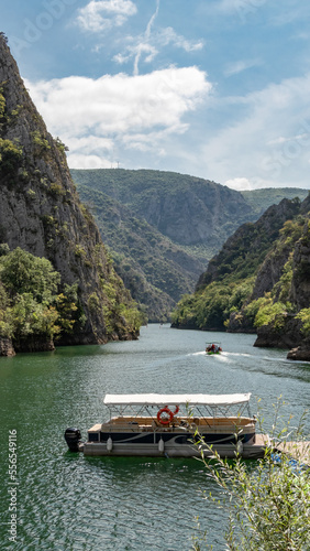 Matka canyon in North Macedonia near Skopje, boat on the lake, boat trip, Matka lake and mountain view with sky, colorful boat for tourists, vertical