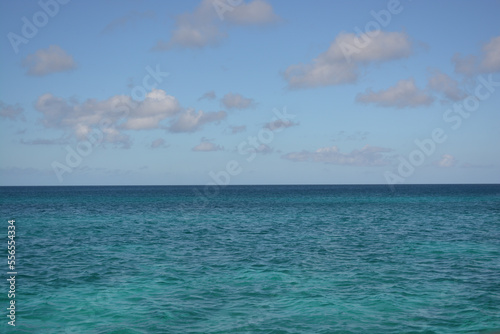 Azure Caribbean sea meets blue sky. Space for copy. 