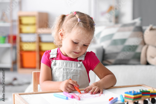 Cute little girl drawing with felt-tip pen at home