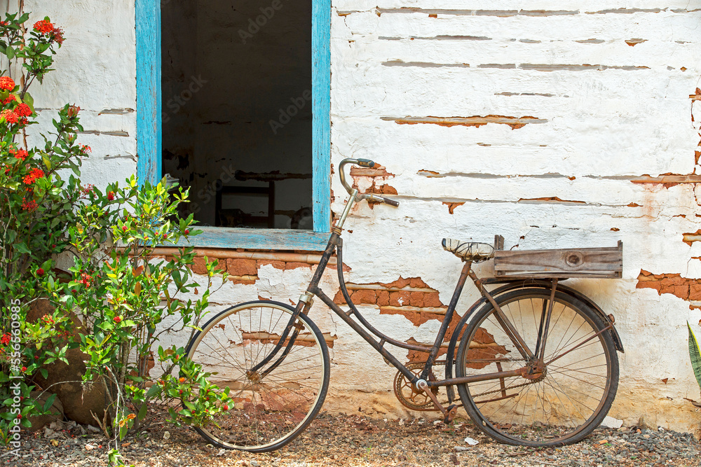 Old bicycle leaning against the wall of rural house on Brazil