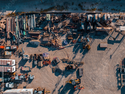 Cranes move metal to compactor. Metal recycling industrial area. Aerial view of machineries working at scrap metal recycling yard.