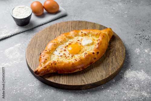 ajara Khachapuri with cheese, egg and butter, georgian kitchen on grey table