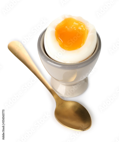 Cup with soft boiled egg and spoon on white background