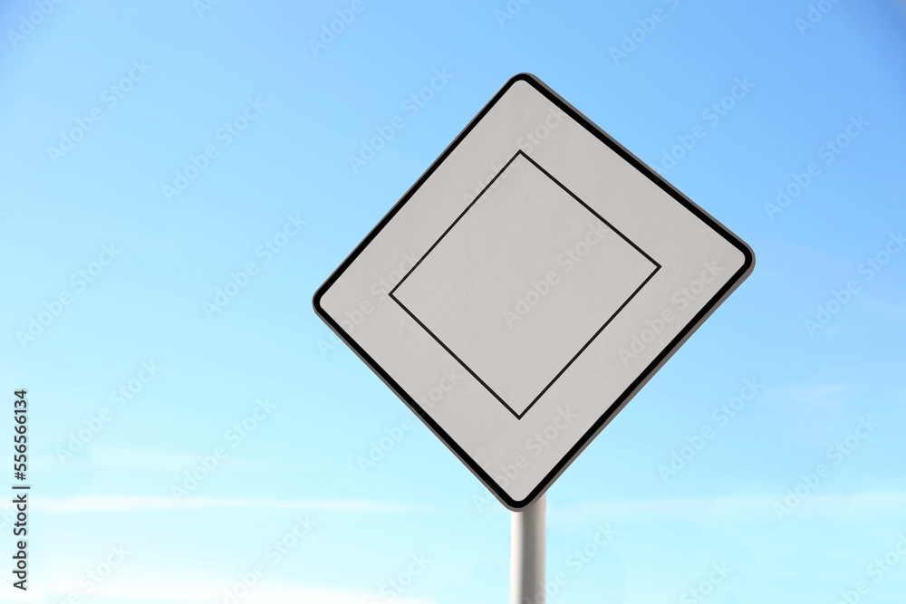 Priority road sign against blue sky on city street Priority road sign against blue sky on city street