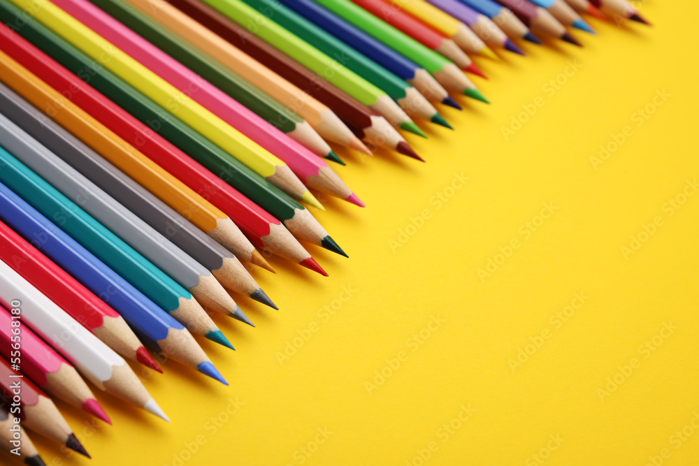 Colorful wooden pencils on yellow background, closeup. Space for text Colorful wooden pencils on yellow background, closeup. Space for text