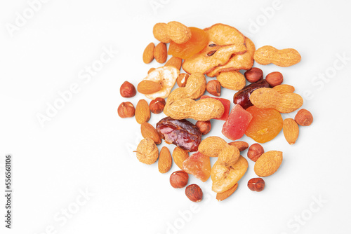 Pile of mixed dried fruits and nuts on white background, flat lay. Space for text