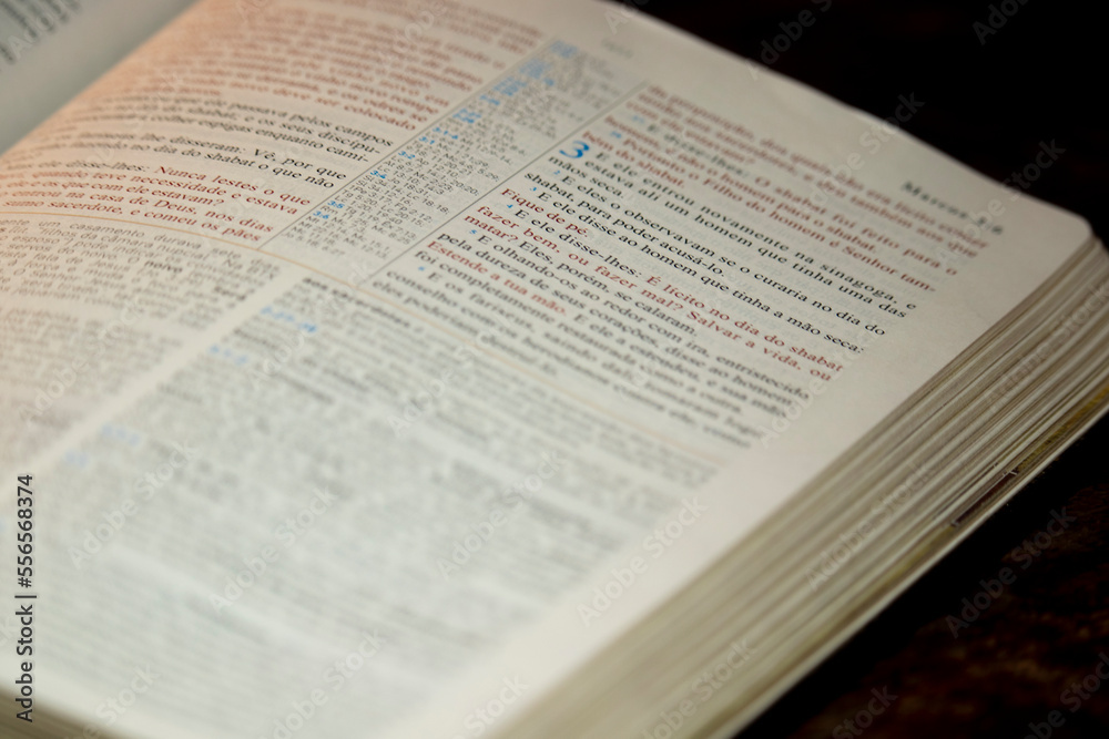 holy bible open on a wooden table in one of the pages of the gospels holy bible open on a wooden table in one of the pages of the gospels