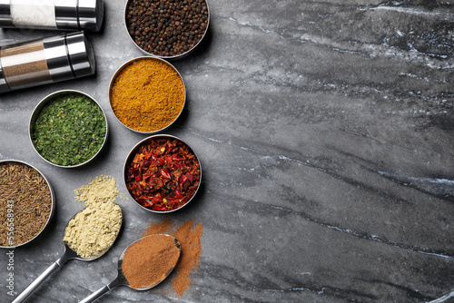 Fototapeta Naklejka Na Ścianę i Meble -  Flat lay composition with different spices on grey marble table, space for text