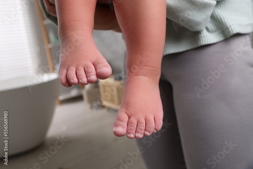 Mother with her daughter after bath, closeup. Focus on child`s feet