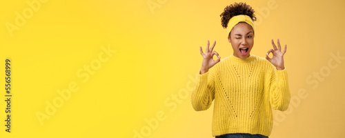 Okay I got it. Cute reliable truthful african-american girlfriend assuring friend secret safe winking devious hinting work done okay show ok fine perfect gesture no worry about, yellow background photo