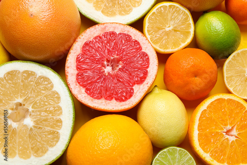 Different ripe citrus fruits as background, top view