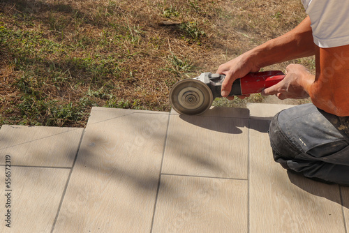 Fotografie Finition d'une terrasse - Découpe des lames de carrelage posées pour les ajuster