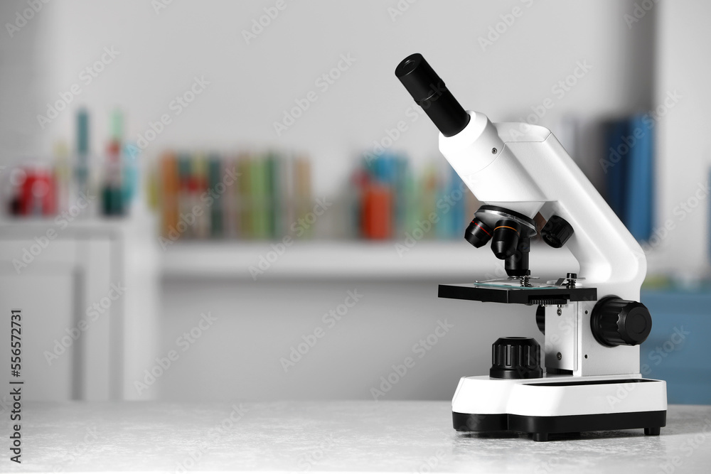 Modern medical microscope on white table in laboratory, space for text Modern medical microscope on white table in laboratory, space for text